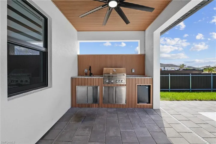 View of patio with area for grilling and ceiling fan