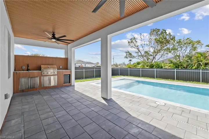 View of pool with a patio, area for grilling, an outdoor kitchen, and ceiling fan