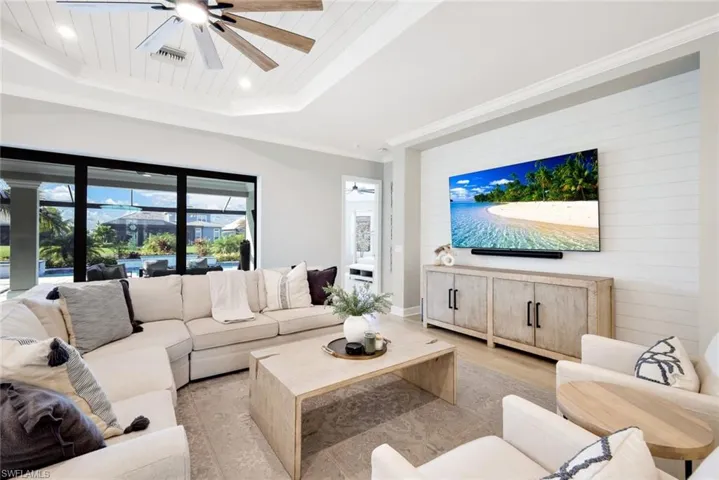 Living area featuring ceiling fan, wood finished floors, crown molding, recessed lighting, and wood walls