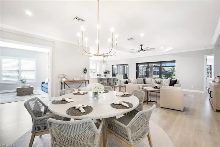 Dining space featuring a chandelier, crown molding, light wood-style floors, ceiling fan, and recessed lighting