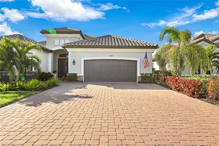 Mediterranean / spanish-style house featuring stone siding, stucco siding, decorative driveway, and a tile roof