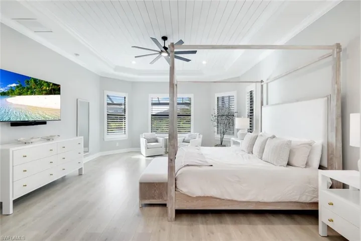 Bedroom with light wood-style flooring, ceiling fan, wooden ceiling, recessed lighting, and a tray ceiling