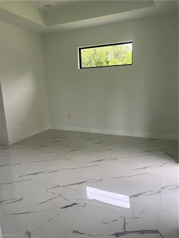 Spare room with tile flooring and a raised ceiling