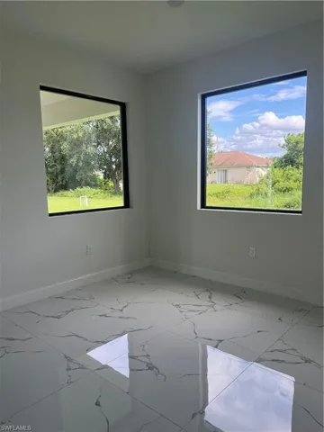 Empty room with a healthy amount of sunlight and tile floors