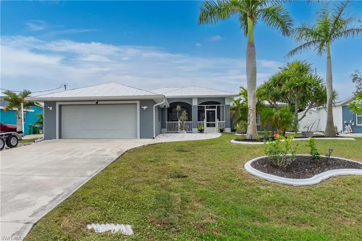 Single story home featuring a garage and a front lawn