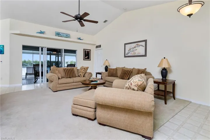 Living room featuring high vaulted ceiling, carpet, and ceiling fan