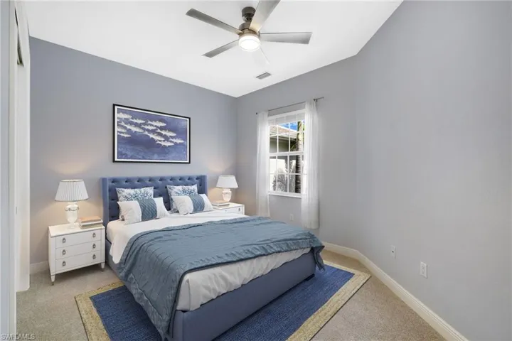 Bedroom with ceiling fan and light colored carpet