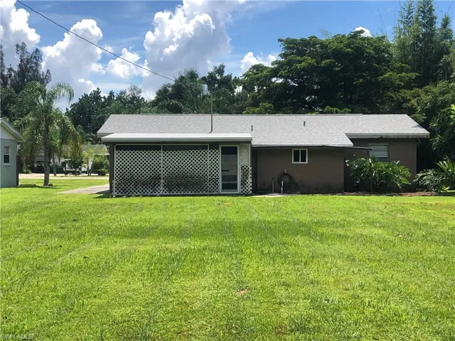 Rear view of house featuring a yard