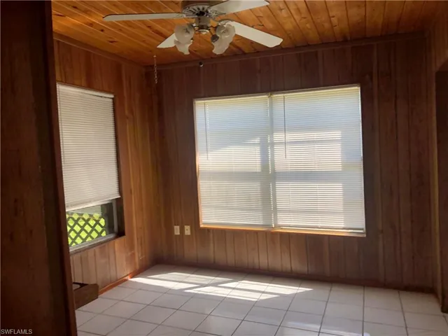 Dining room or room with wood ceiling, wood walls, and ceiling fan