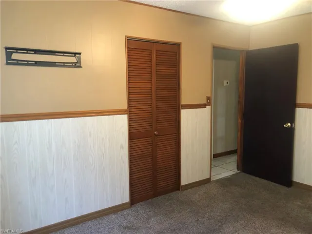 Unfurnished bedroom featuring light colored carpet and a closet
