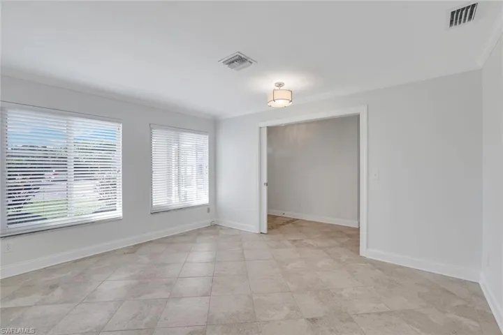 Unfurnished room with ornamental molding and light tile patterned floors. Could be a large 3rd bedroom or office.