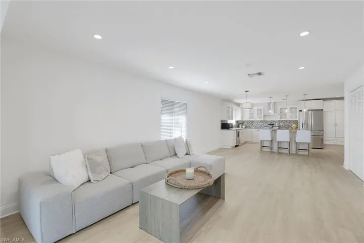Sun filled living room with light vinyl/ wood-style flooring.