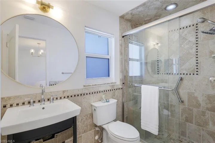 Ensuite Master Bathroom featuring tile walls, a shower with shower door, and vanity.