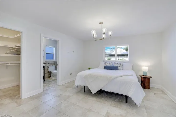 Master Bedroom with a spacious walk-in closet, ensuite bath, and light tile patterned floors.