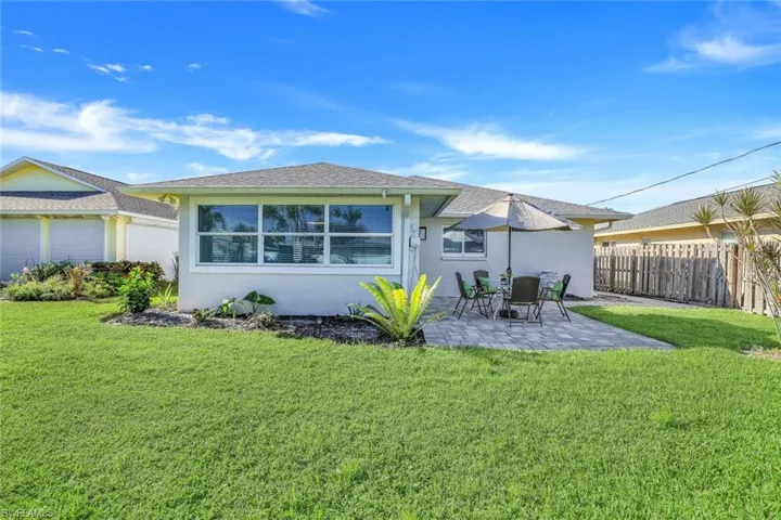 Back of property featuring a large backyard and a patio.