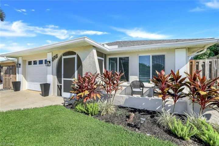 Front view of property featuring an outdoor front open lanai, large yard, and single car garage.