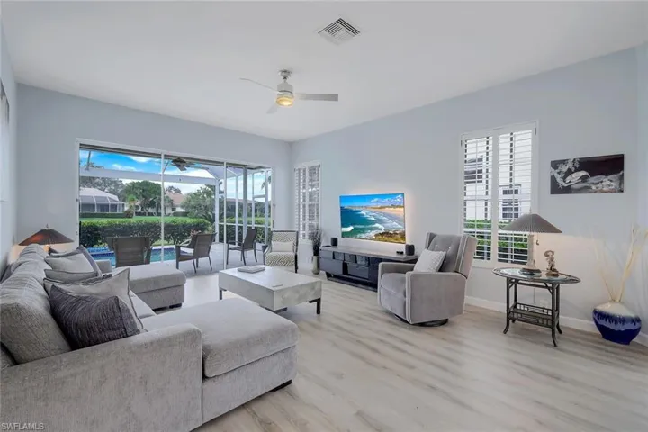 Living room featuring light hardwood / wood-style flooring, ceiling fan, and a healthy amount of sunlight
