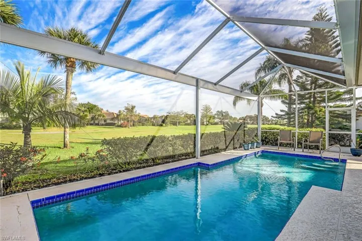 View of swimming pool with glass enclosure and a patio