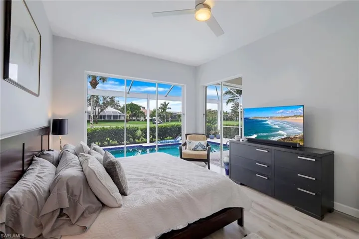 Bedroom with access to exterior, light wood-type flooring, and ceiling fan