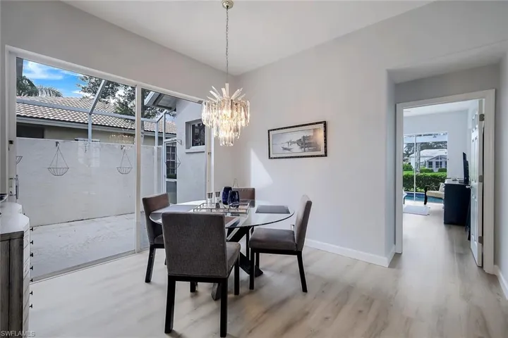 Dining space featuring light hardwood / wood-style flooring, a wealth of natural light, and a notable chandelier