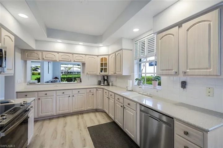 Kitchen featuring decorative backsplash, sink, stainless steel appliances, and light hardwood / wood-style flooring