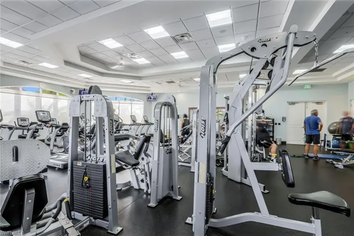 Gym with a tray ceiling and a drop ceiling