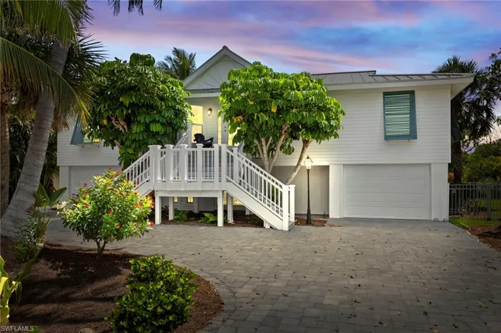 View of front of property featuring decorative driveway, an attached garage, a porch, a metal roof, and a standing seam roof