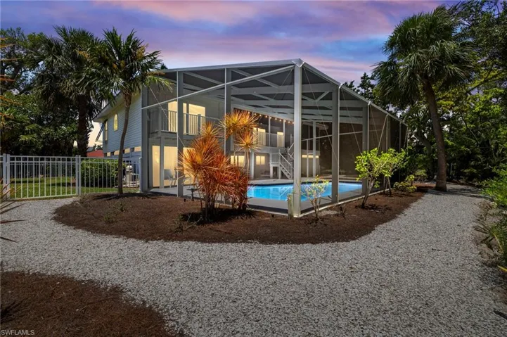 Back of property with an outdoor pool and a lanai
