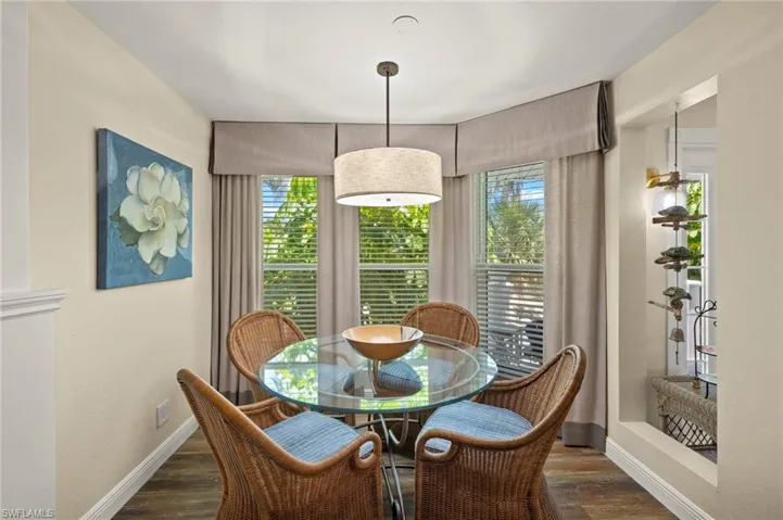 Dining room with plenty of natural light and dark wood-style flooring