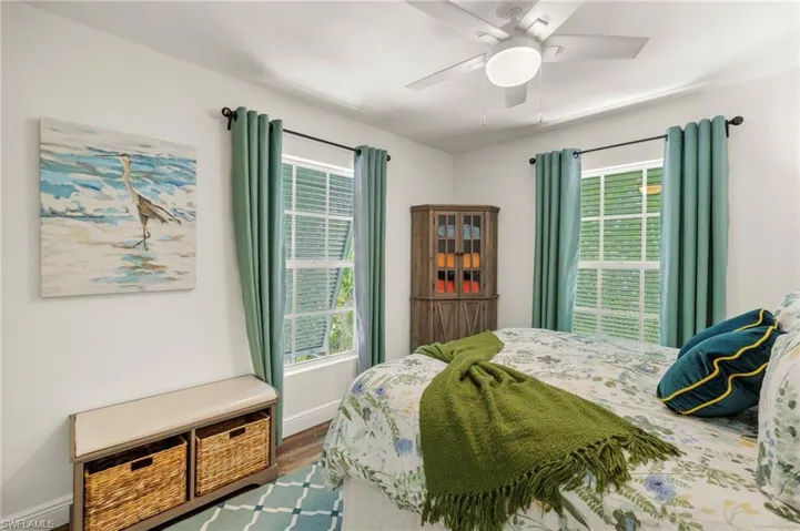 Bedroom with dark wood-style flooring and a ceiling fan