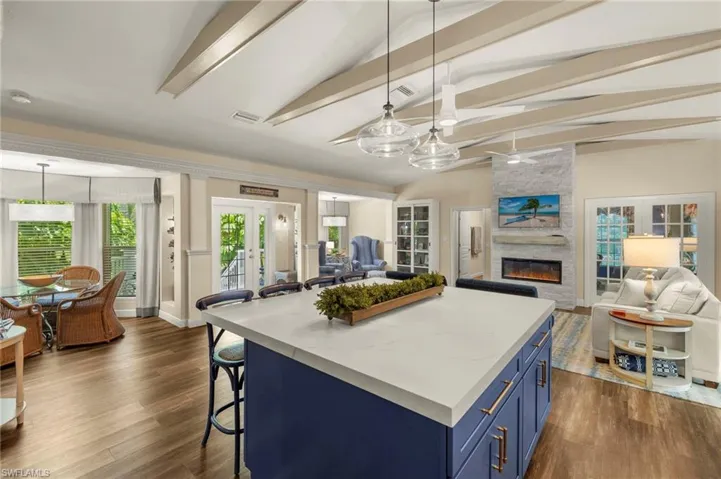Kitchen with blue cabinetry, open floor plan, a kitchen bar, and dark wood finished floors