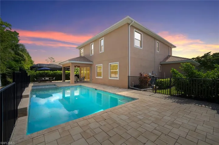 Pool at dusk featuring a patio area