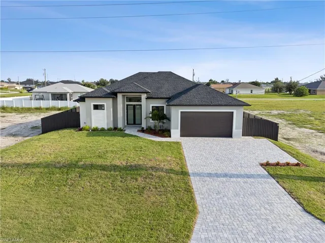 View of front of home with a garage and a front lawn