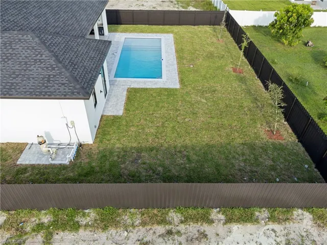 View of pool with a lawn