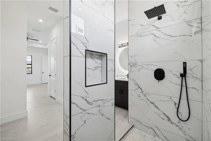 Bathroom with vanity, ceiling fan, a tile shower, and wood-type flooring