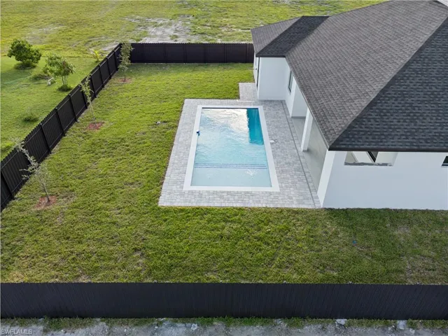 View of pool with a yard