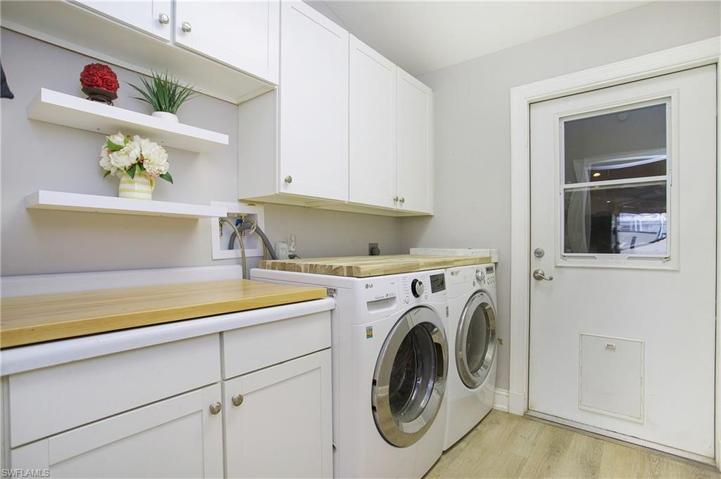 Spacious laundry room with folding counter and lots of storage, with an exit to the garage.