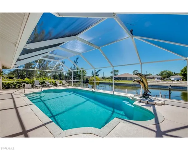 View of swimming pool with a water view, glass enclosure, and a patio area