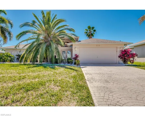 View of front of home featuring french doors, a front lawn, and a garage