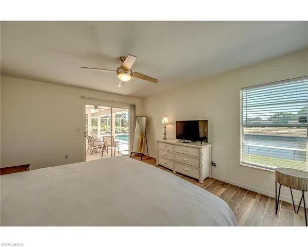 Bedroom with access to exterior, light wood-type flooring, and ceiling fan