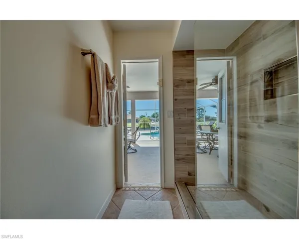 Doorway to outside with ceiling fan and light tile patterned flooring