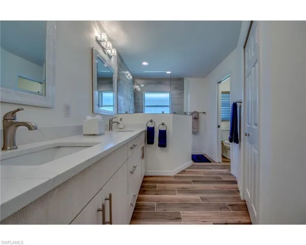 Bathroom with a tile shower, vanity, and toilet