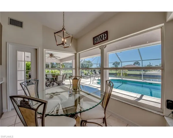Tiled dining room with ceiling fan with notable chandelier