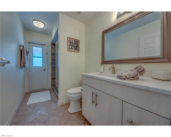 Bathroom featuring vanity, toilet, and a shower with shower door