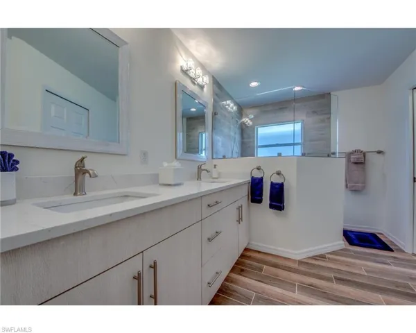 Bathroom featuring a tile shower and vanity