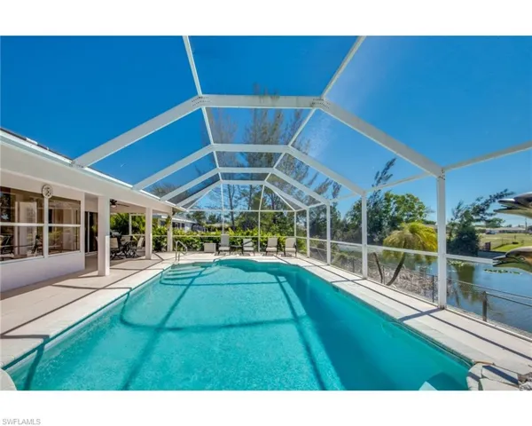 View of swimming pool with a patio area, a lanai, and a water view