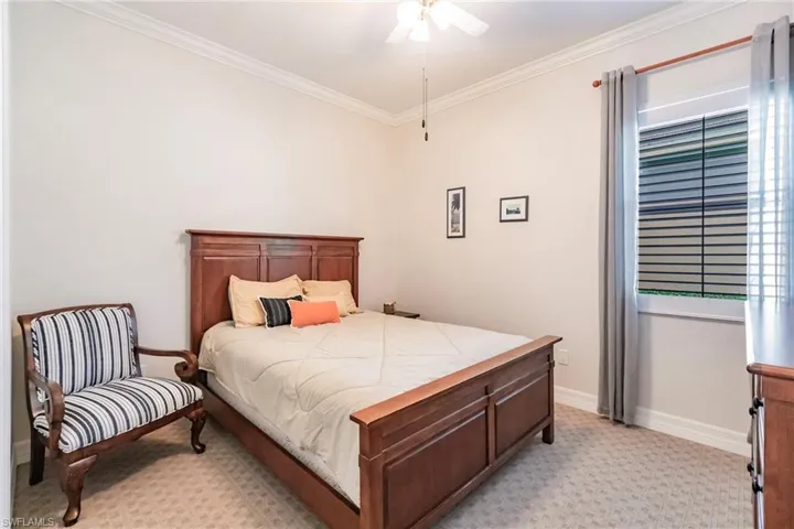 Bedroom featuring ceiling fan, light colored carpet, and ornamental molding