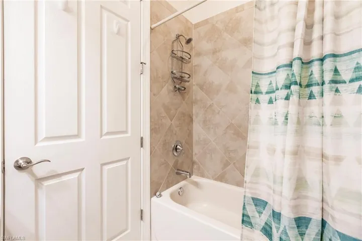 Bathroom with shower / bath combination with curtain