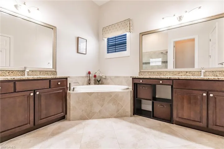 Bathroom with tile floors, tiled bath, and vanity