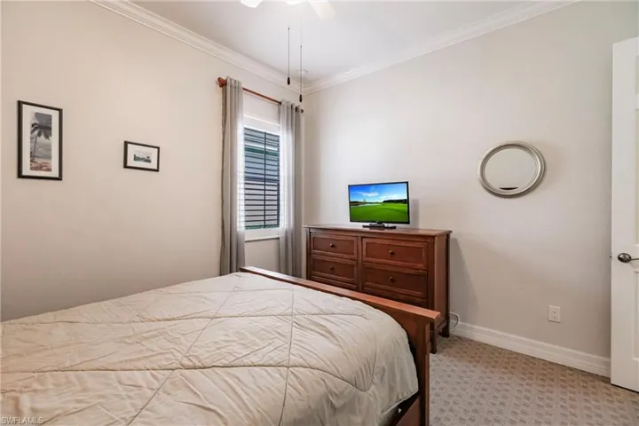 Bedroom with carpet, ceiling fan, and ornamental molding
